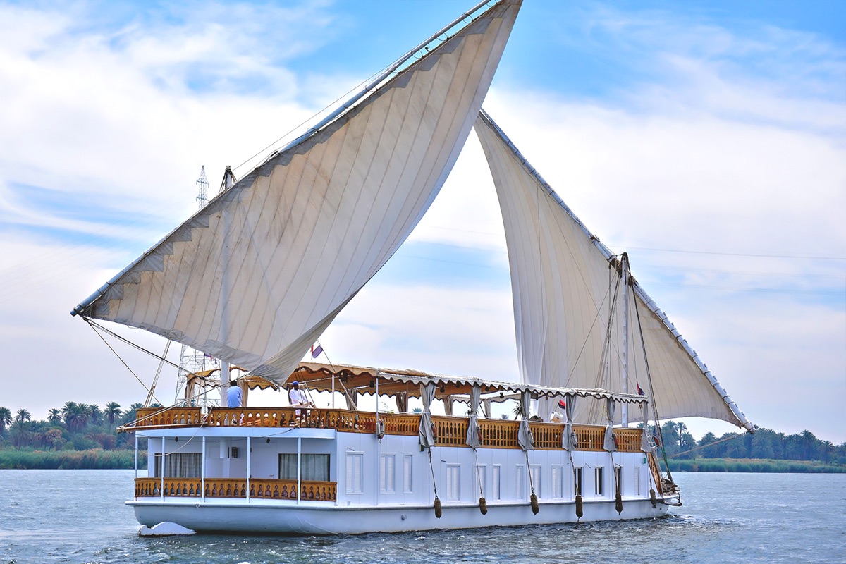 Traditional Dahabiya sailing on the Nile at sunset